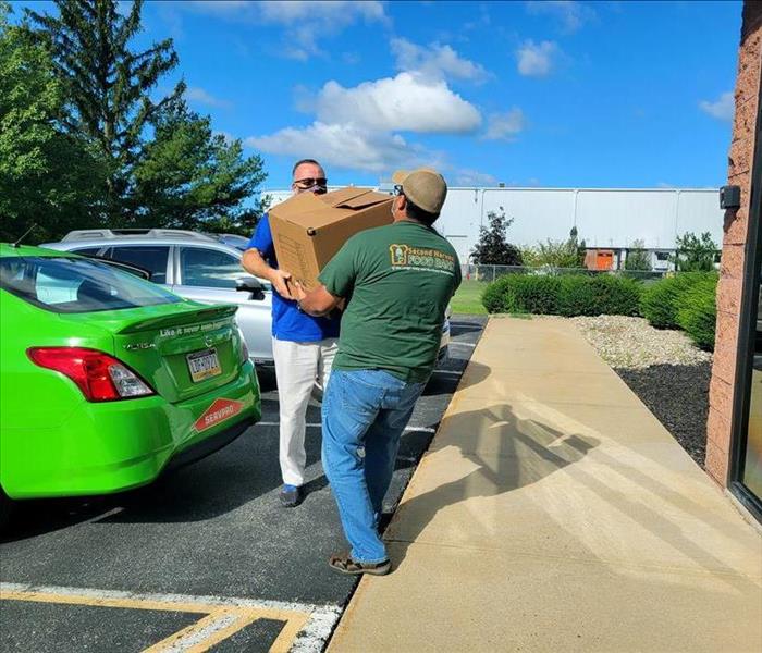 two men handing eachother a box