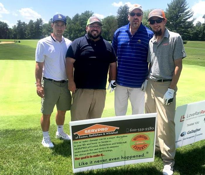 Four men standing on golf course