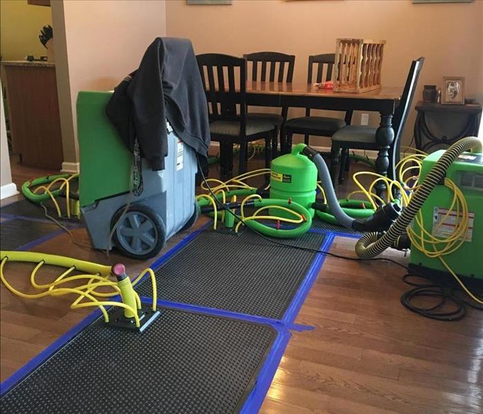 Drying equipment set up on floor in a dining room.