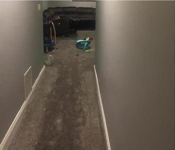 wet carpet, hallway, end of hallway black couch